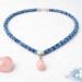 Flat lay of Bead & Braid Collective Kumihimo necklace with rose quartz pendant, blue glass beads and silver findings